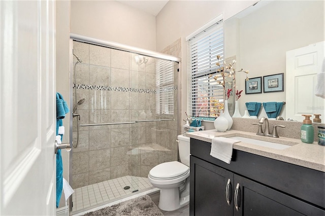 bathroom with vanity, toilet, and a shower stall
