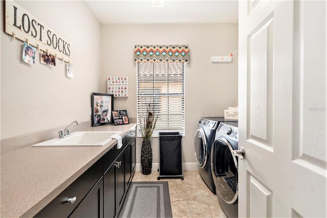 washroom with light tile patterned floors, separate washer and dryer, cabinet space, and a sink