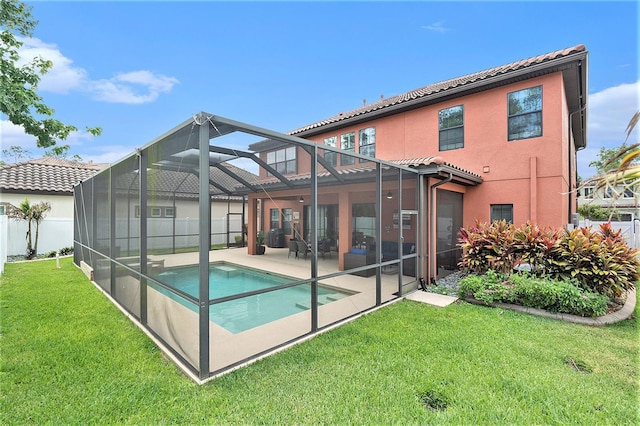 rear view of house featuring a yard, a tiled roof, a patio, an outdoor pool, and stucco siding
