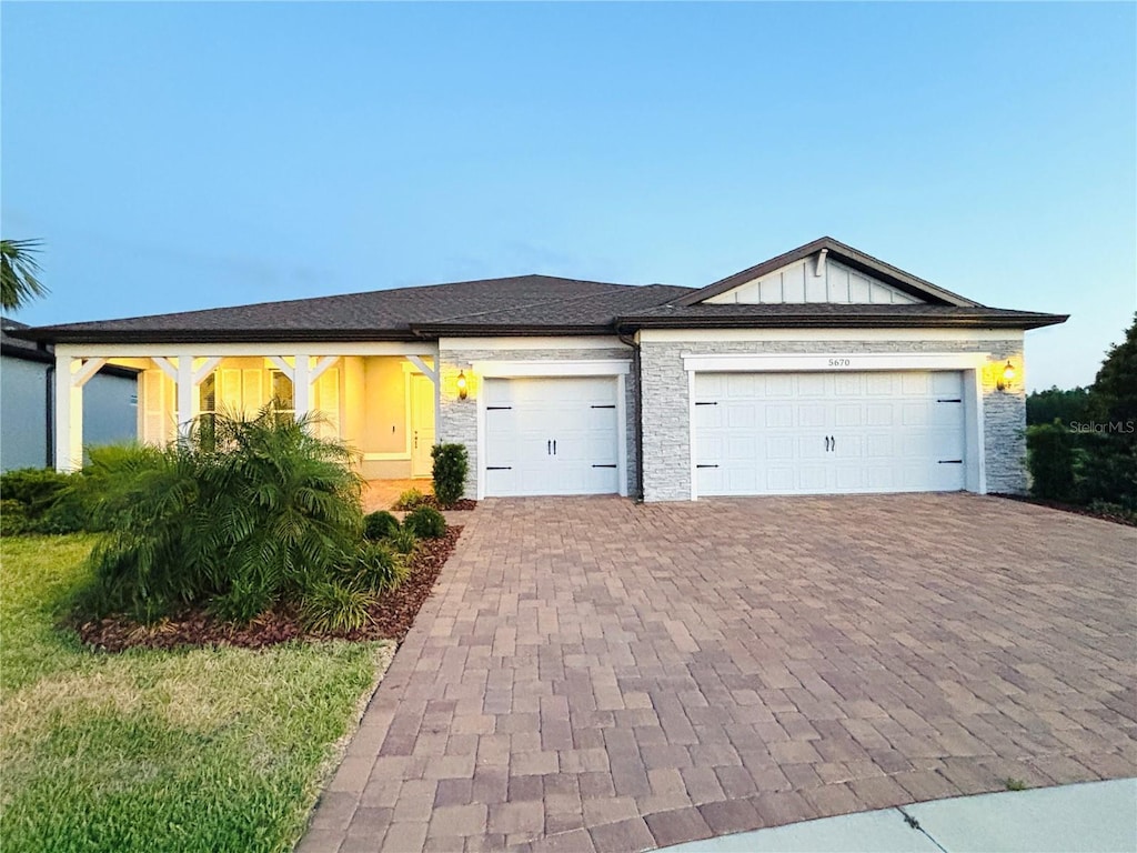 single story home featuring an attached garage and decorative driveway