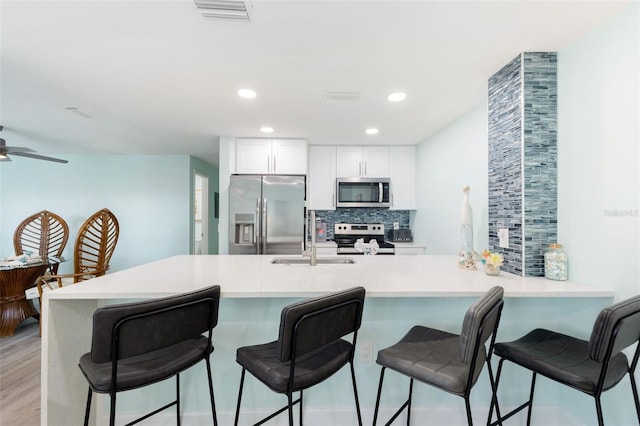 337 Rex Pl Unit G, Madeira Beach, FL 33708 - kitchen featuring a sink, white cabinetry, visible vents, backsplash, and appliances with stainless steel finishes