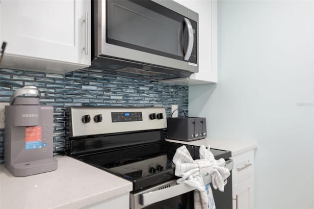 337 Rex Pl Unit G, Madeira Beach, FL 33708 - kitchen with white cabinetry, light countertops, stainless steel appliances, and tasteful backsplash
