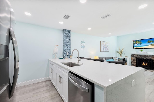 337 Rex Pl Unit G, Madeira Beach, FL 33708 - kitchen featuring a sink, a peninsula, appliances with stainless steel finishes, visible vents, and light wood-style floors