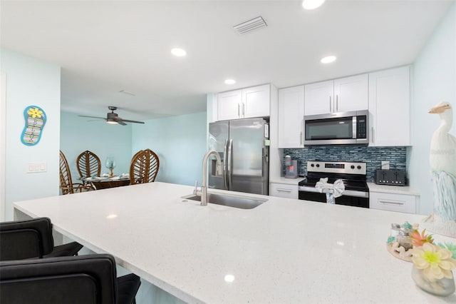 337 Rex Pl Unit G, Madeira Beach, FL 33708 - kitchen with visible vents, a sink, white cabinetry, backsplash, and appliances with stainless steel finishes