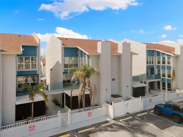337 Rex Pl Unit G, Madeira Beach, FL 33708 - view of property featuring fence and uncovered parking