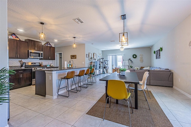 dining space featuring light tile patterned floors, baseboards, and visible vents