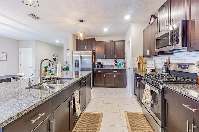 kitchen with light tile patterned floors, visible vents, a sink, decorative backsplash, and appliances with stainless steel finishes