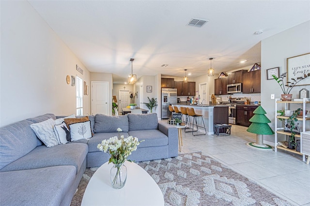 living area with light tile patterned floors and visible vents