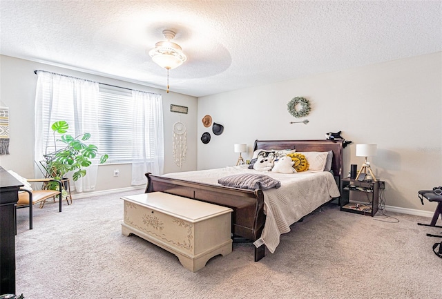 bedroom featuring ceiling fan, light carpet, a textured ceiling, and baseboards