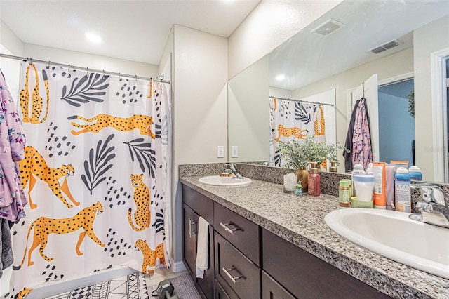 bathroom with visible vents, a sink, and double vanity