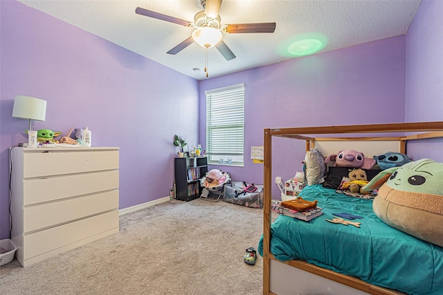 carpeted bedroom featuring ceiling fan and a textured ceiling