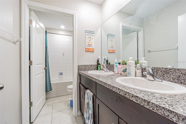 bathroom with toilet, tile patterned flooring, double vanity, and a sink