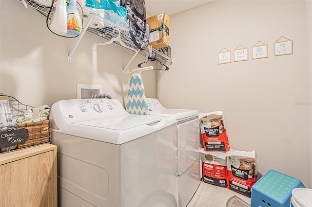 clothes washing area featuring laundry area, independent washer and dryer, and tile patterned floors