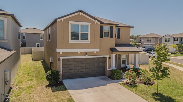 view of front of property featuring concrete driveway, a front yard, stucco siding, and a garage