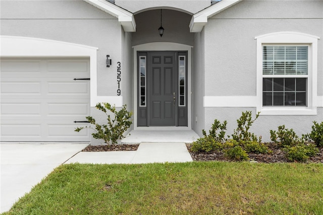 doorway to property featuring stucco siding and a garage