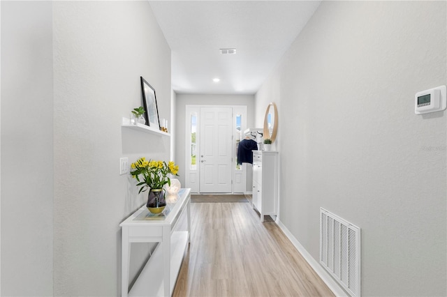 hallway with light wood-type flooring and baseboards