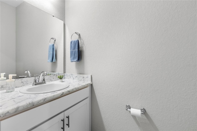 bathroom featuring vanity and a textured wall