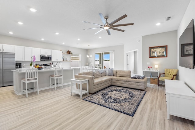 living area featuring light wood-style floors, ceiling fan, and recessed lighting