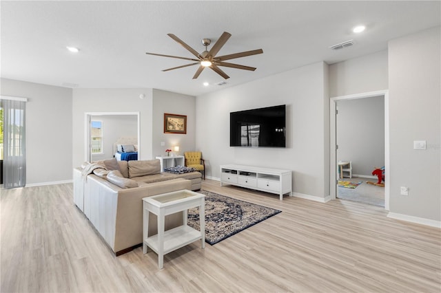 living area with light wood-style floors, a ceiling fan, recessed lighting, and baseboards