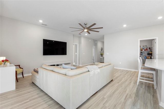 living room featuring light wood-type flooring, ceiling fan, recessed lighting, and baseboards