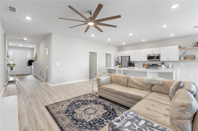living area with light wood finished floors, ceiling fan, recessed lighting, and baseboards