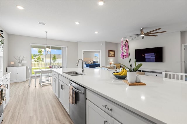 kitchen with a sink, stainless steel dishwasher, open floor plan, light countertops, and ceiling fan