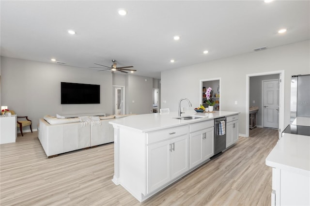 kitchen with a sink, dishwasher, light countertops, a center island with sink, and recessed lighting