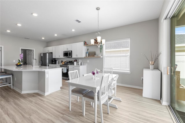 dining space with plenty of natural light, light wood finished floors, a chandelier, and recessed lighting