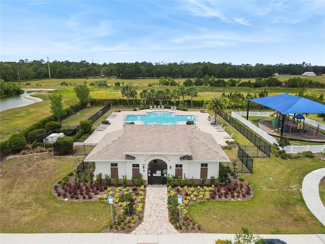 view of pool with view of scattered trees and a water view