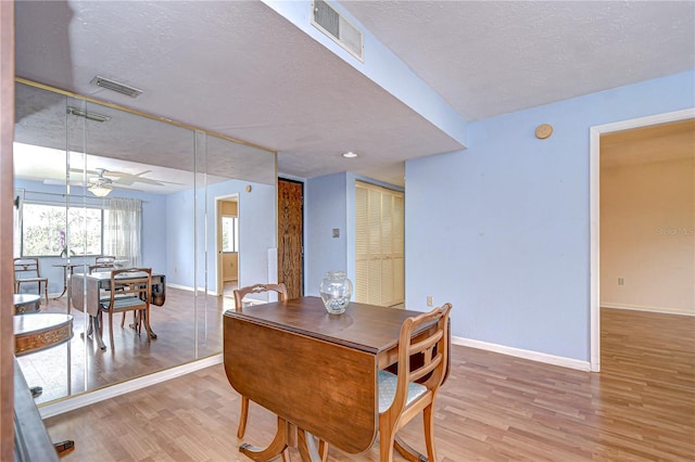 dining room featuring baseboards, visible vents, and wood finished floors