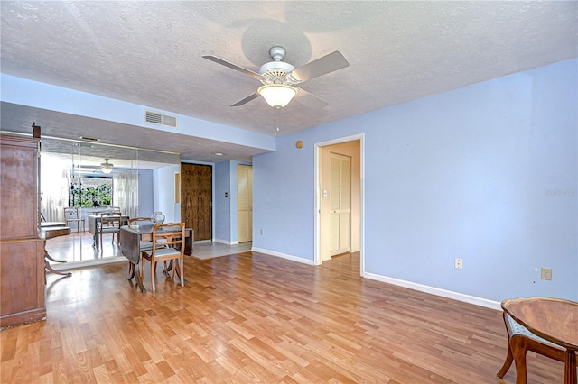 dining room with ceiling fan, baseboards, light wood-type flooring, and visible vents