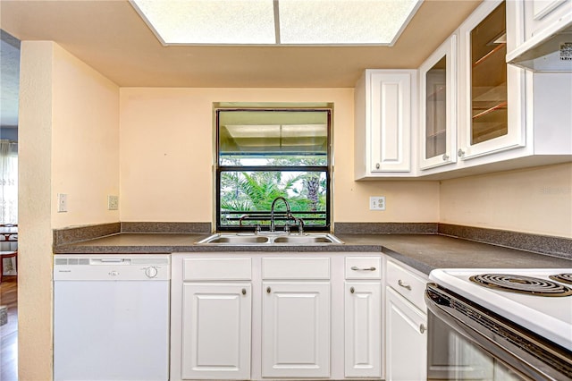 kitchen with a sink, white cabinetry, dark countertops, and white dishwasher