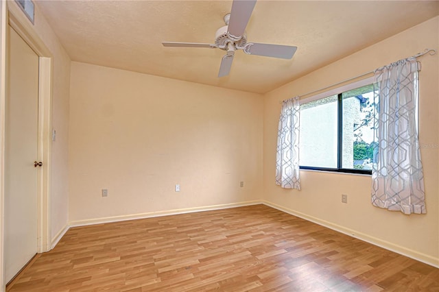 empty room with baseboards, light wood-style flooring, and a ceiling fan