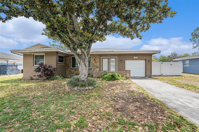 ranch-style home with brick siding, fence, a garage, concrete driveway, and a gate