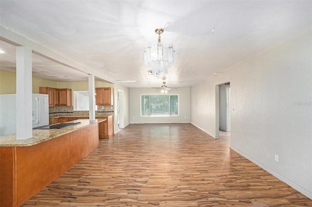 interior space featuring an inviting chandelier, light wood-type flooring, and baseboards