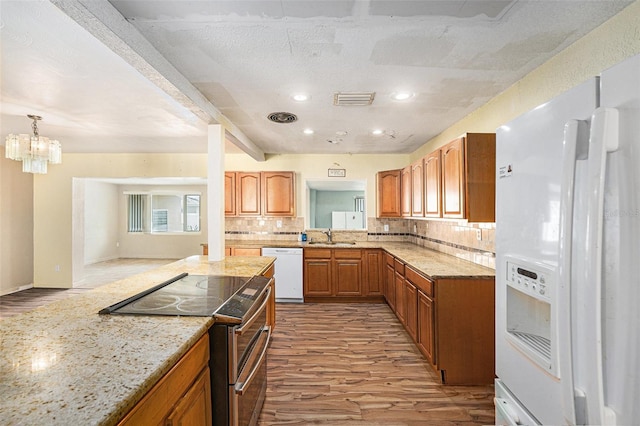 kitchen featuring backsplash, white appliances, a sink, and wood finished floors