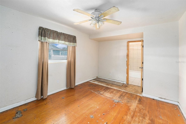 unfurnished room featuring a ceiling fan, baseboards, and hardwood / wood-style flooring