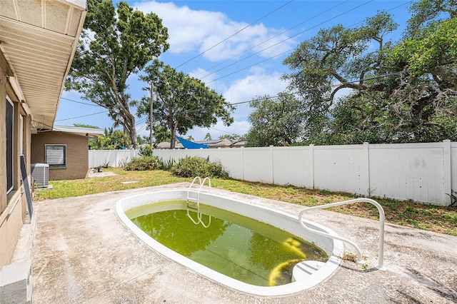 view of swimming pool featuring central AC and a fenced backyard
