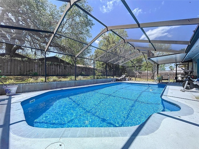 view of swimming pool with a fenced backyard, a patio area, a fenced in pool, and glass enclosure