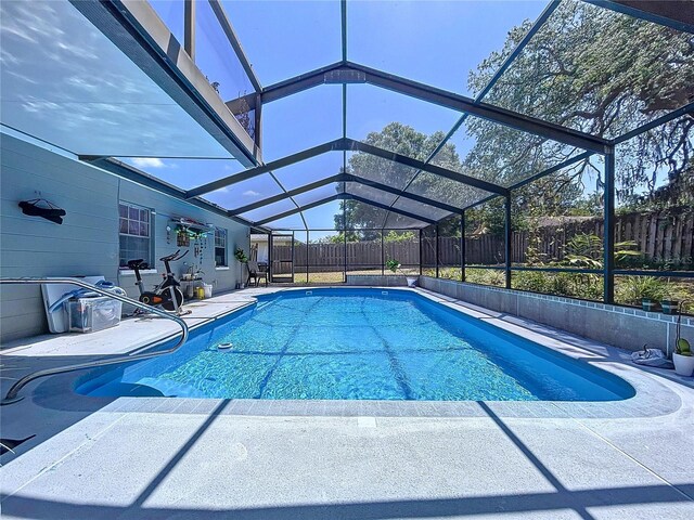view of pool featuring a fenced backyard, a patio, a fenced in pool, and glass enclosure
