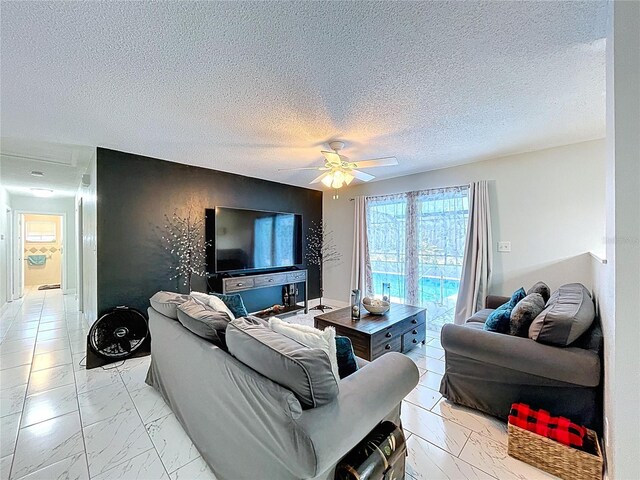 living area with a textured ceiling, marble finish floor, and a ceiling fan