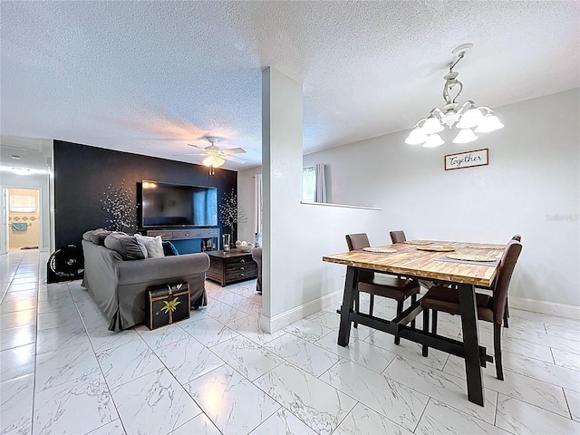dining room with baseboards, marble finish floor, plenty of natural light, and ceiling fan with notable chandelier