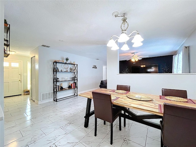 dining space with marble finish floor, visible vents, and a textured ceiling