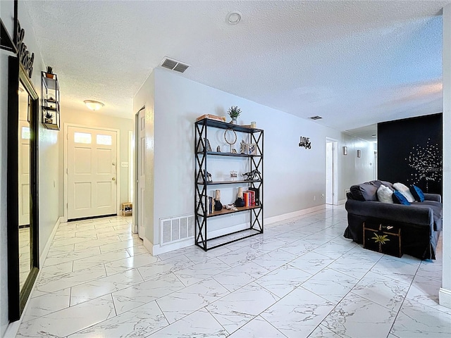 hall with marble finish floor, baseboards, and visible vents