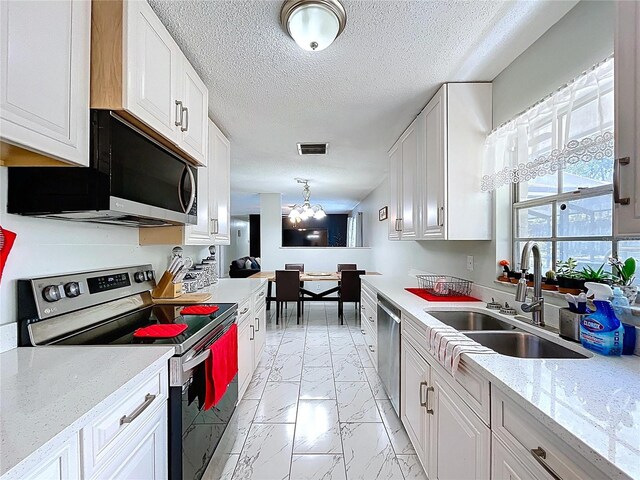 kitchen with marble finish floor, visible vents, a sink, white cabinetry, and stainless steel appliances