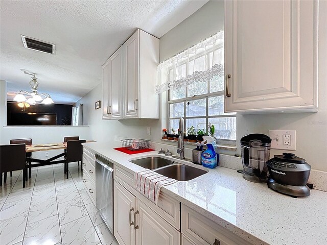 kitchen featuring a sink, a textured ceiling, stainless steel dishwasher, visible vents, and marble finish floor