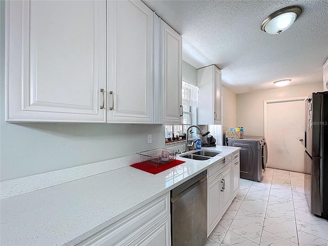 kitchen featuring freestanding refrigerator, dishwasher, marble finish floor, a sink, and separate washer and dryer