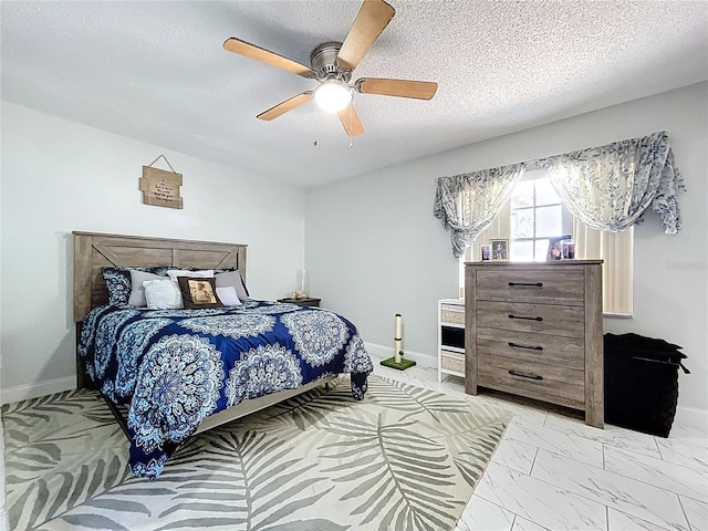 bedroom featuring baseboards, marble finish floor, ceiling fan, and a textured ceiling