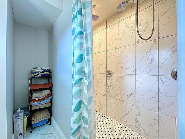 bathroom featuring marble finish floor and tiled shower