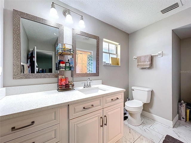 bathroom with toilet, marble finish floor, vanity, a textured ceiling, and visible vents